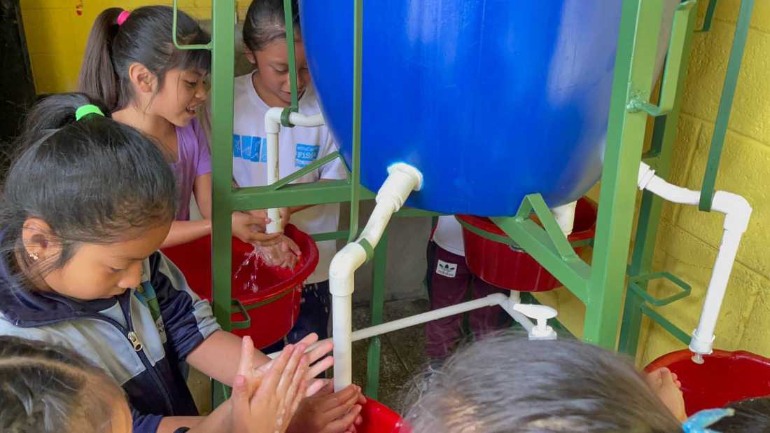 Local school children using WASH sanitation hand washing system in Guatemalan water project |  Los Buenos Vencinos NGO Guatemala
