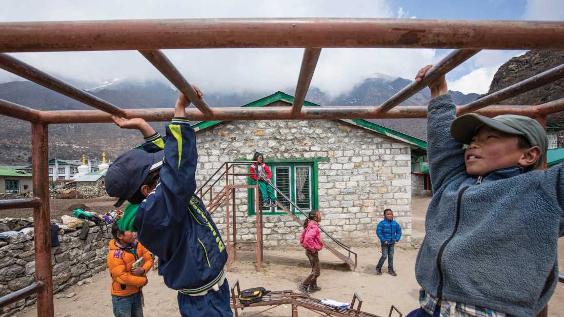 Local children playing on the monkey bars at Khumjung school |  Mark Tipple